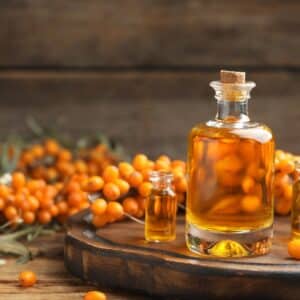 Natural,Sea,Buckthorn,Oil,And,Fresh,Berries,On,Wooden,Table.